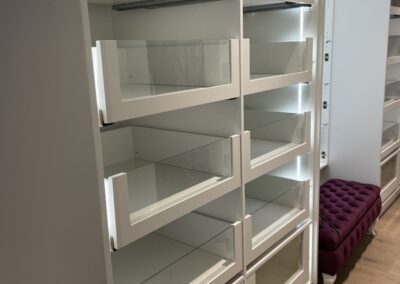 Custom storage space with lit drawers and clear fronts.