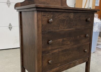 Dark wooden vanity dresser with a mirror at Steinegg Cabinets