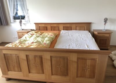 Custom built wooden bed frame with inlaid stars, built by Steinegg Cabinets