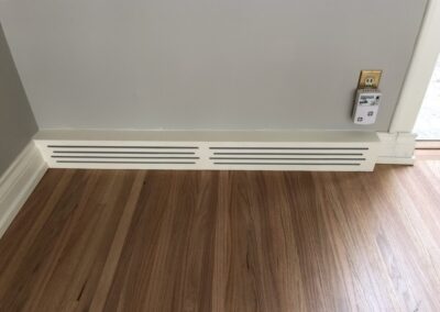 Photo of hardwood flooring meeting the trim of a wall.