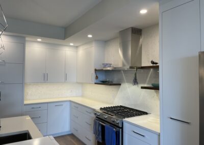 Custom kitchen with white doors, white finish, and a gas stove